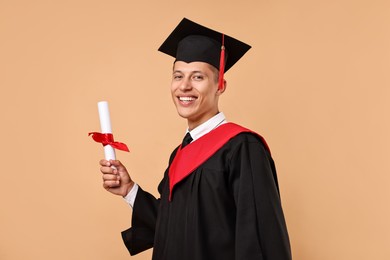 Photo of Happy student with diploma after graduation on beige background