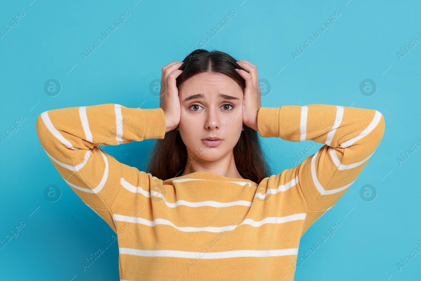 Photo of Stressful student before exam on light blue background