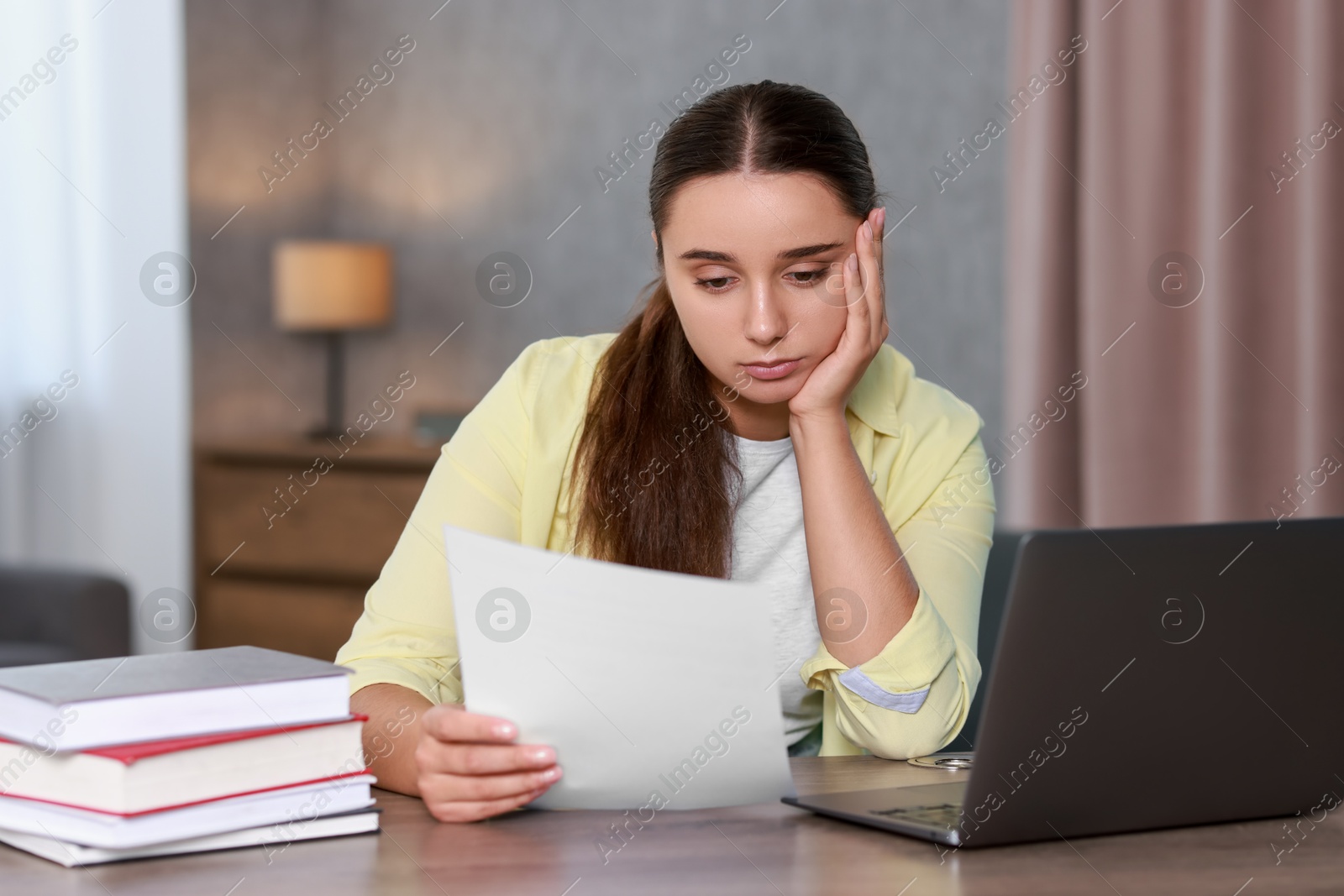 Photo of Young student having stress before exam at desk