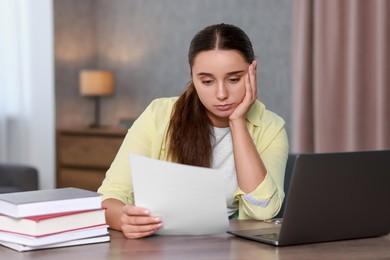 Photo of Young student having stress before exam at desk