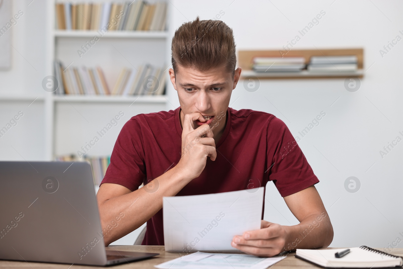 Photo of Tired student having stress before exam at table indoors