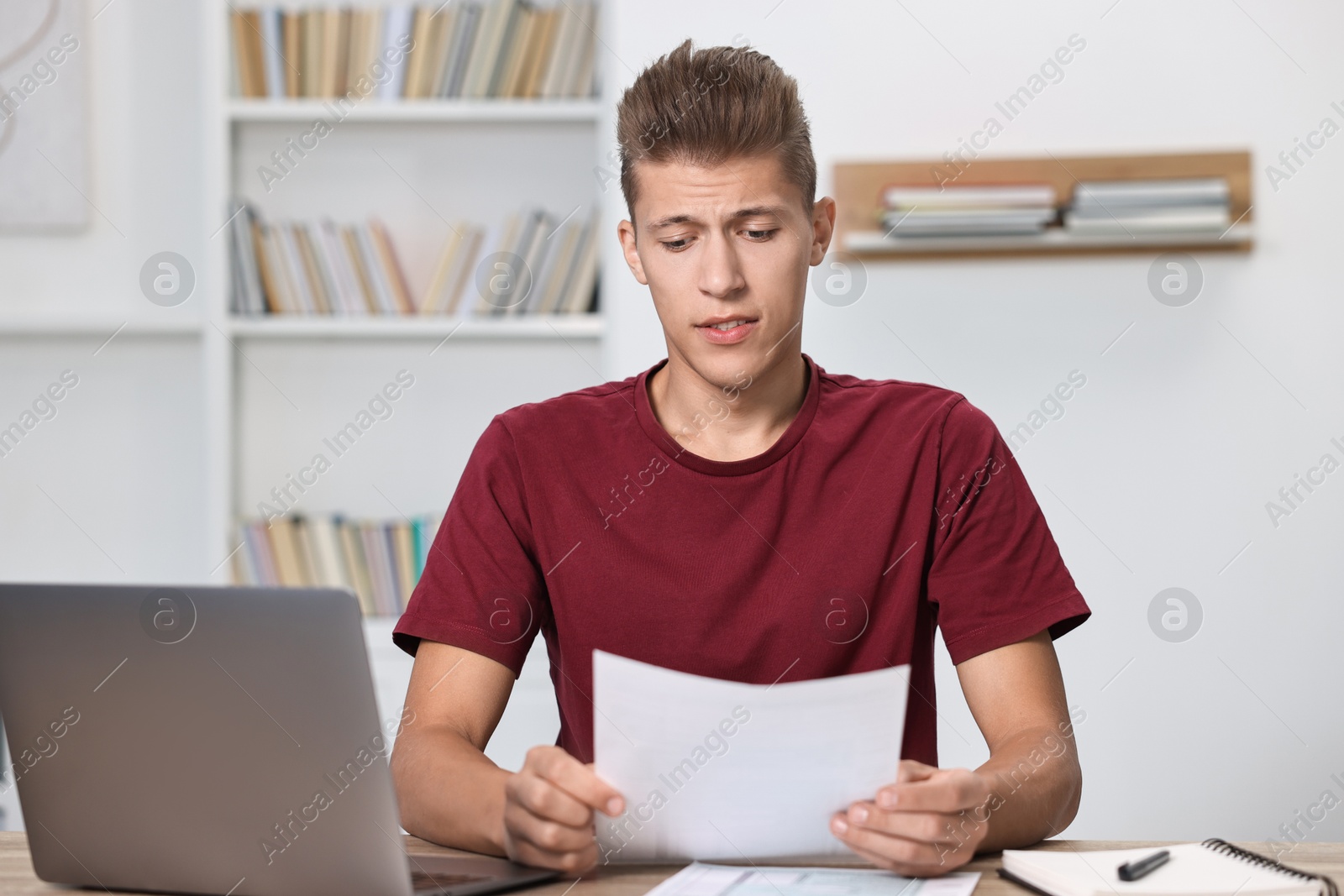 Photo of Tired student having stress before exam at table indoors