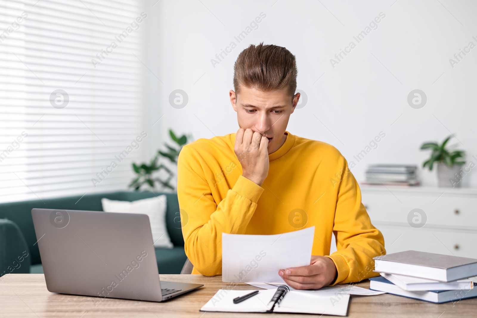 Photo of Tired student having stress before exam at table indoors