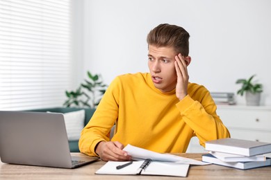 Photo of Tired student having stress before exam at table indoors