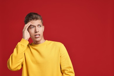 Photo of Emotional student having stress before exam on red background. Space for text