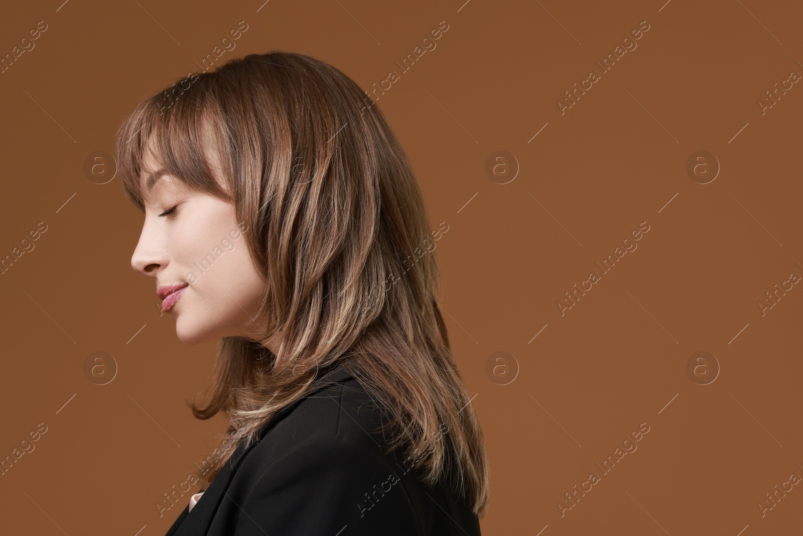 Photo of Attractive woman with stylish haircut on brown background, space for text