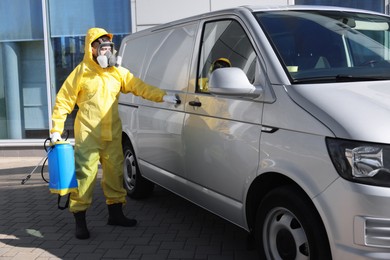 Photo of Pest control worker with spray tank near gray minibus outdoors