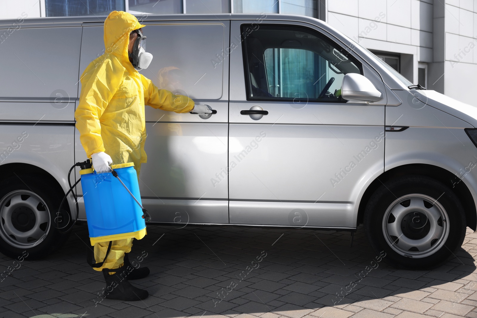 Photo of Pest control worker with spray tank near gray minibus outdoors