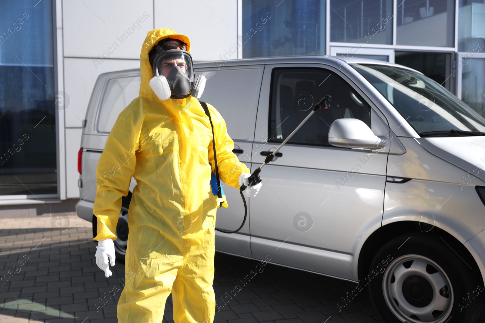 Photo of Pest control worker with spray tank outdoors