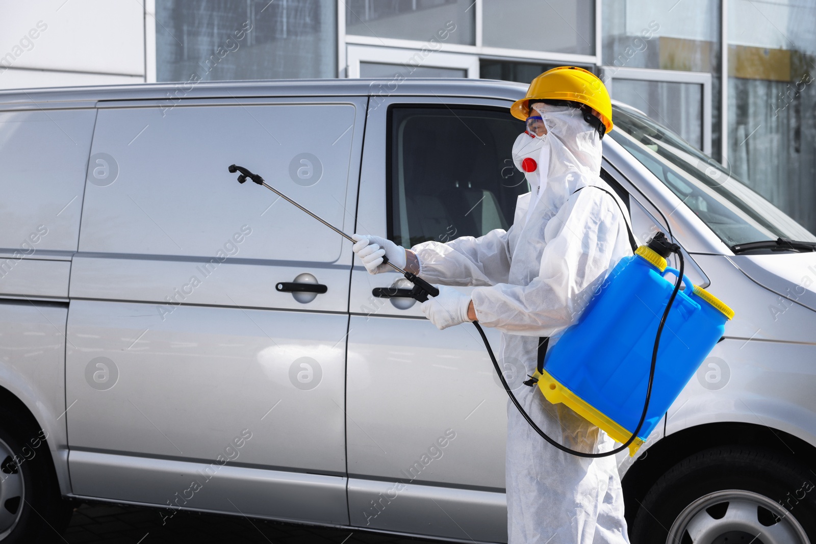 Photo of Pest control worker with spray tank near gray minibus outdoors