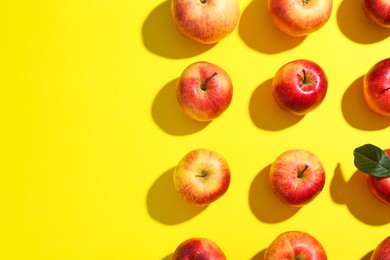 Flat lay composition with many red apples on yellow background. Space for text