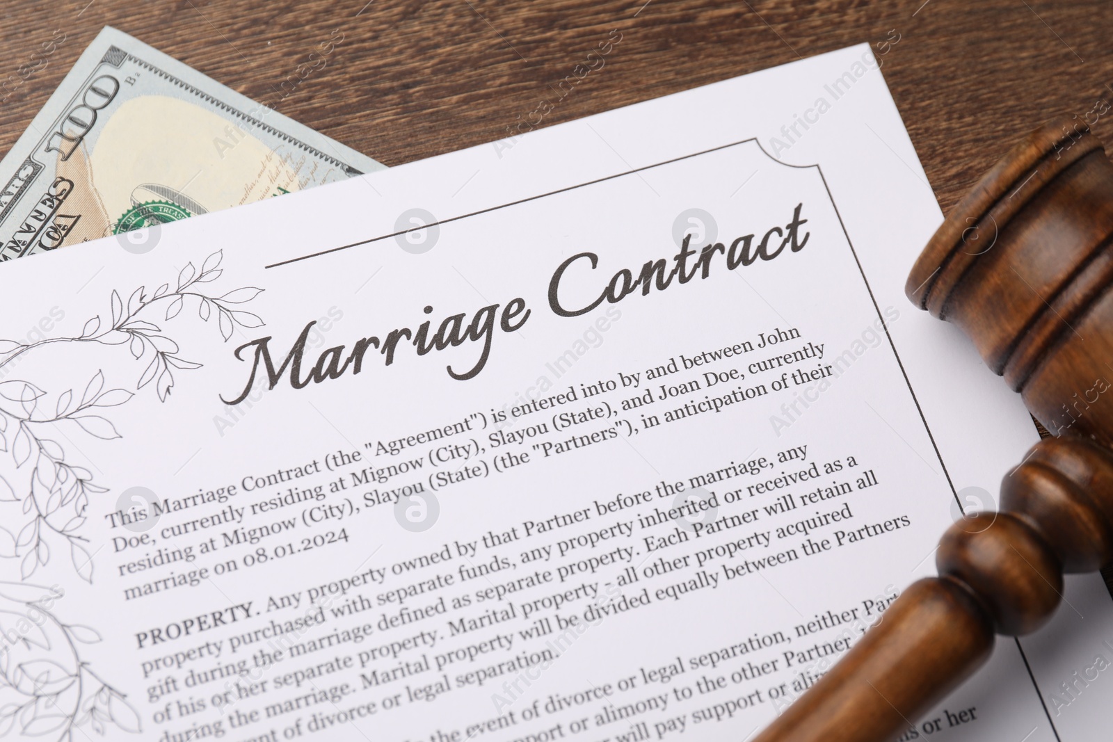 Photo of Marriage contract, gavel and dollar bill on wooden table, top view