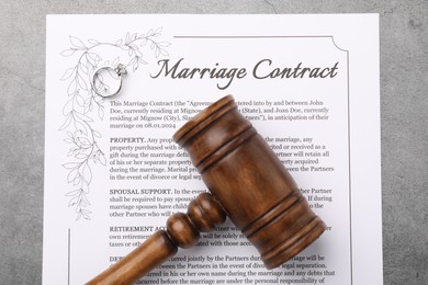 Marriage contract and gavel on grey table, top view