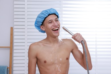 Photo of Man with cap taking shower in bathroom