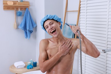 Man with cap taking shower in bathroom