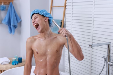 Photo of Man with cap taking shower in bathroom