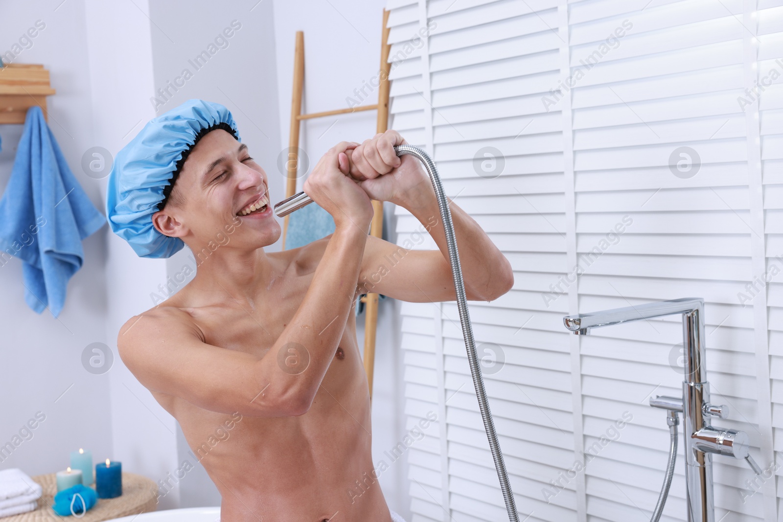 Photo of Man with cap singing while taking shower in bathroom