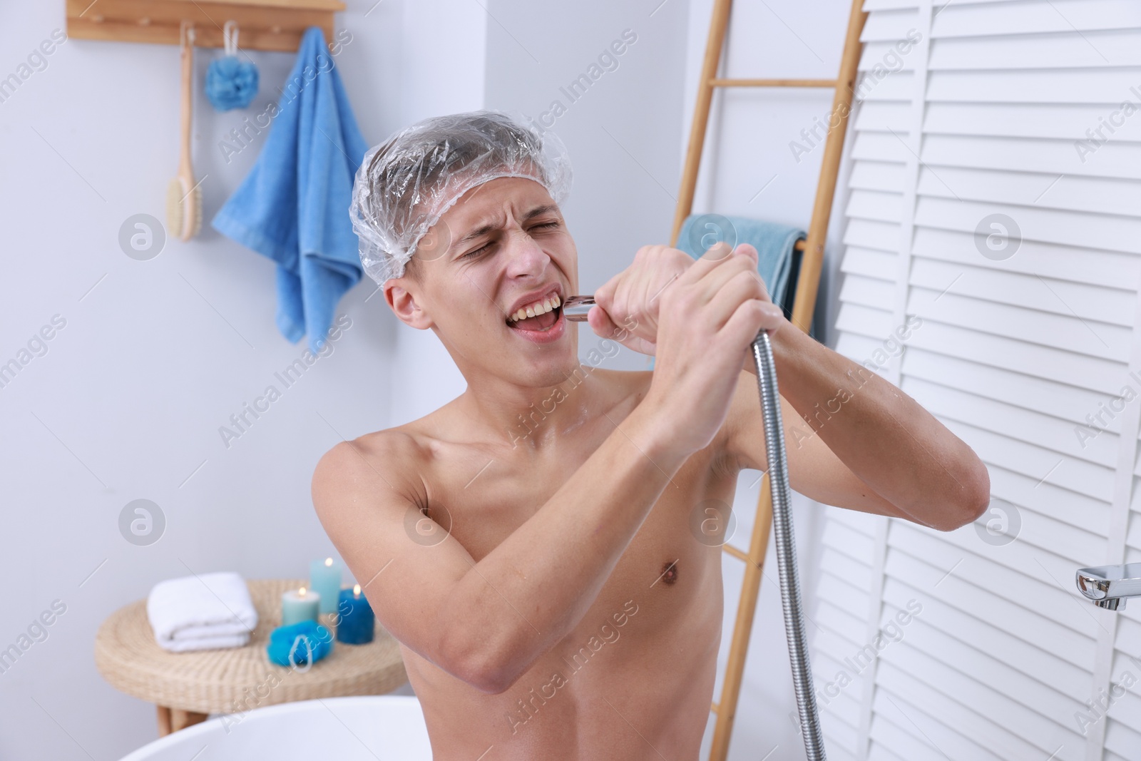 Photo of Man with cap singing while taking shower in bathroom