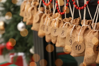 Photo of Christmas advent calendar with gifts and decor hanging indoors, closeup. Space for text