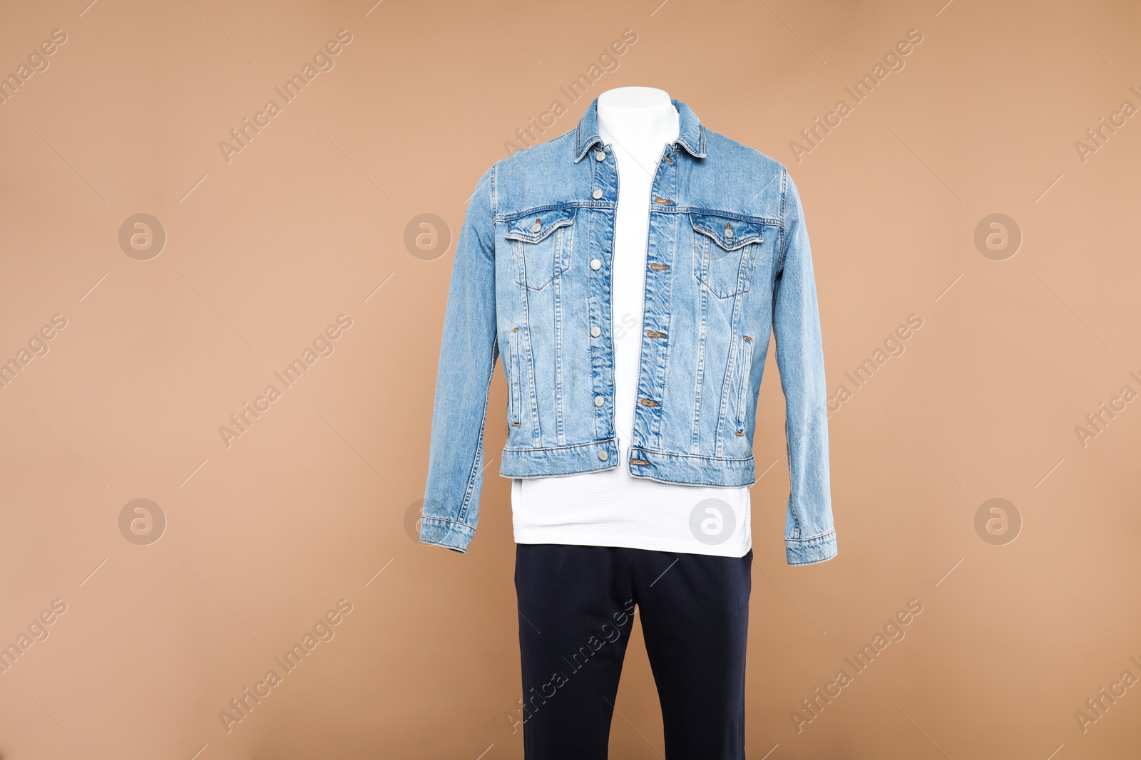 Photo of Male mannequin with stylish outfit on light brown background