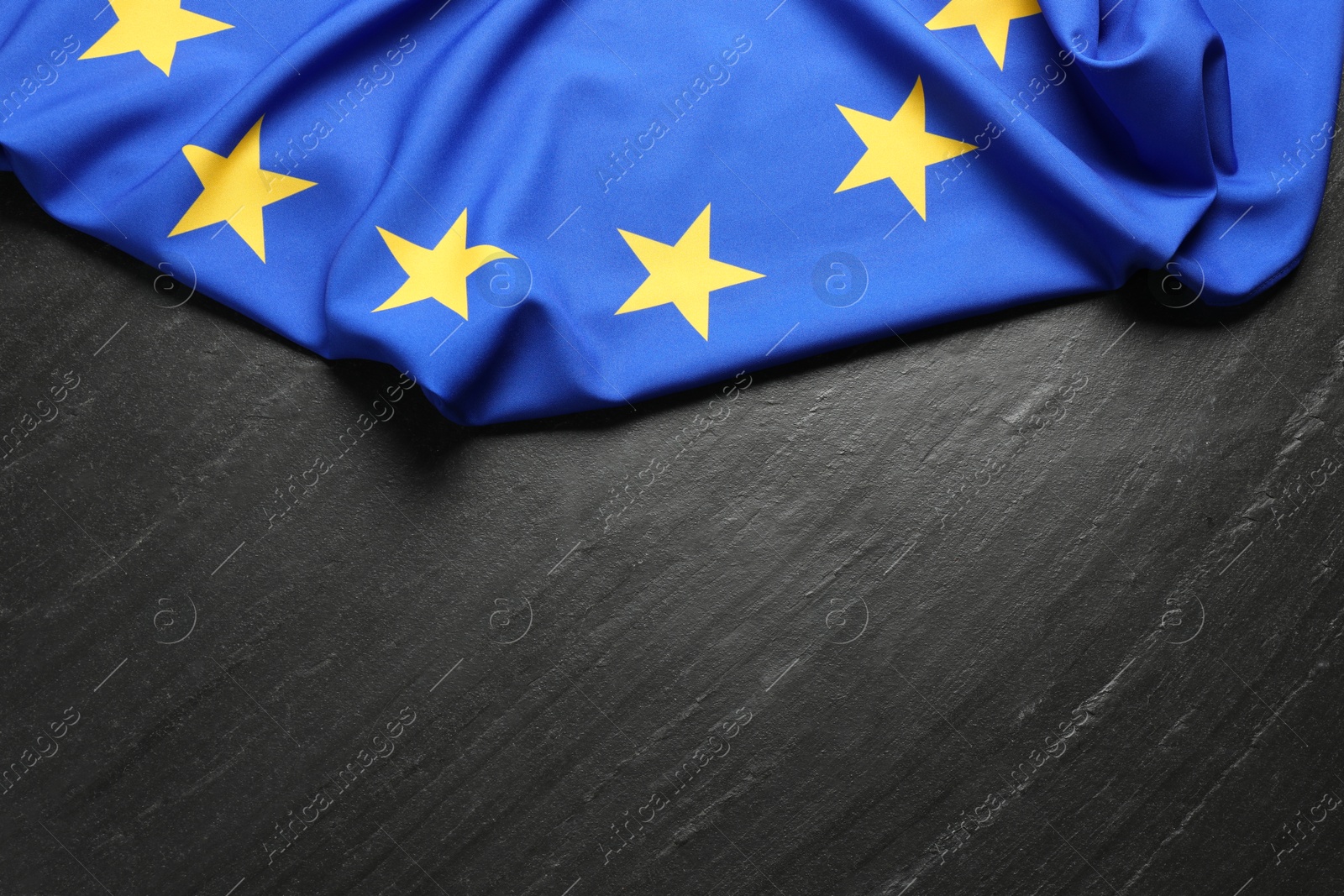 Photo of Flag of European Union on black textured background, top view. Space for text