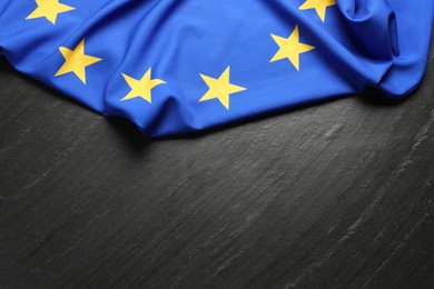 Photo of Flag of European Union on black textured background, top view. Space for text