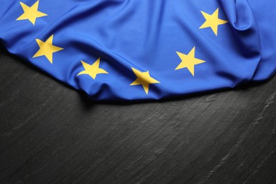 Photo of Flag of European Union on black textured background, top view. Space for text