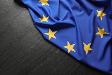 Photo of Flag of European Union on black textured background, top view. Space for text