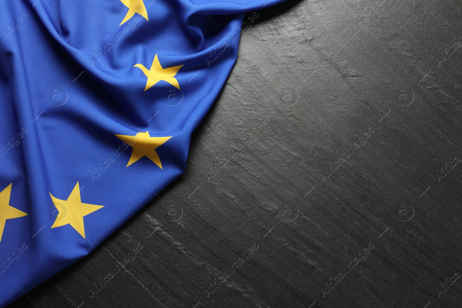 Photo of Flag of European Union on black textured background, top view. Space for text