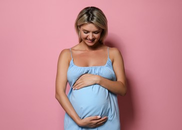 Photo of Portrait of beautiful pregnant woman on pink background