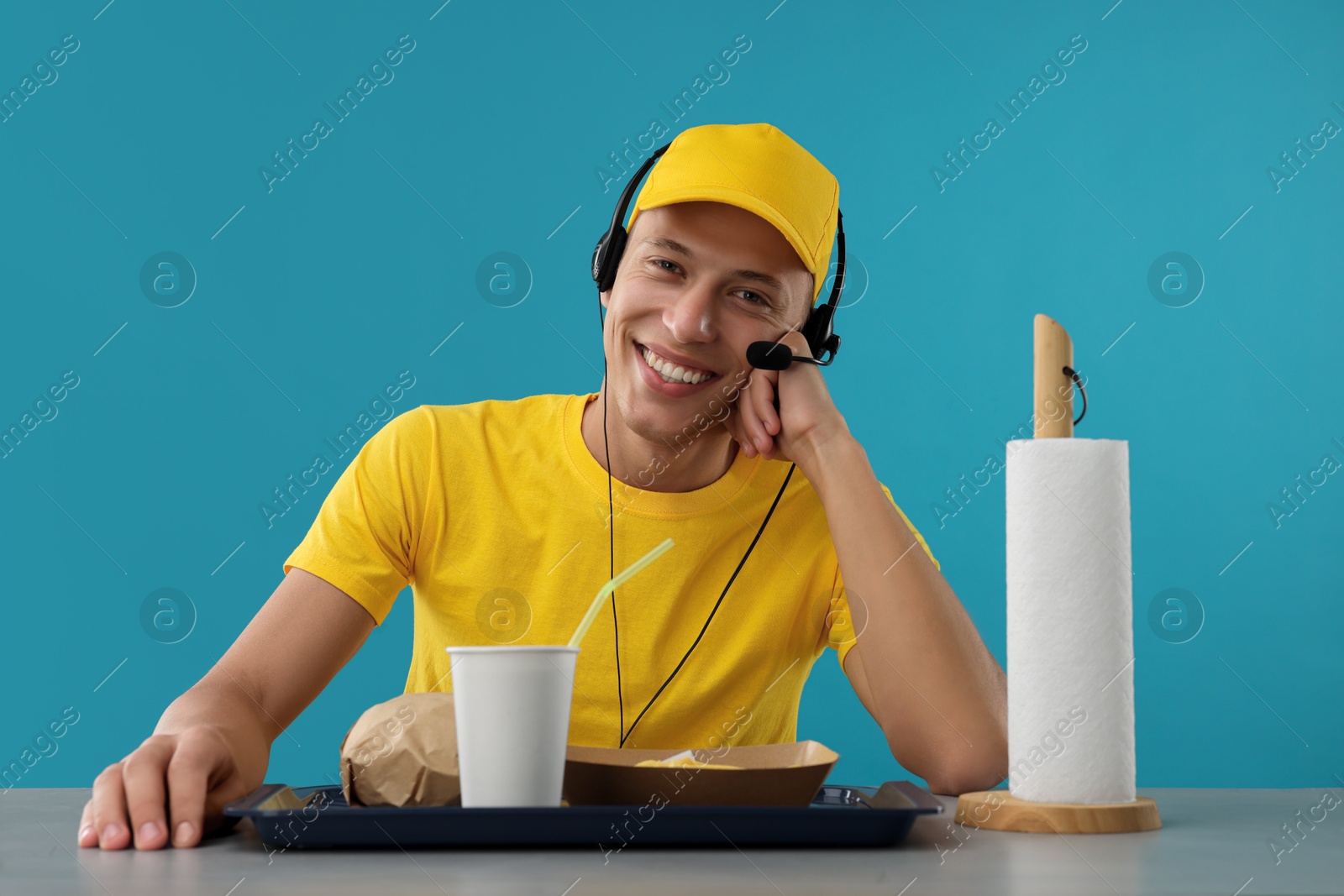 Photo of Fast-food worker with order at counter against light blue background