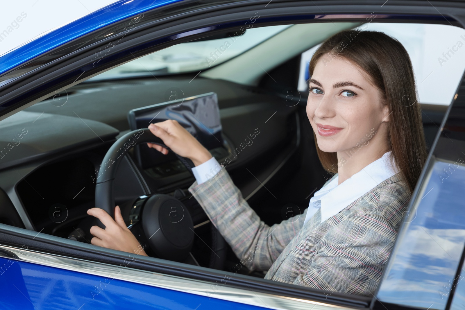 Photo of Young woman inside new car in salon