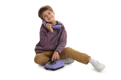 Photo of Cute little boy with old telephone on white background