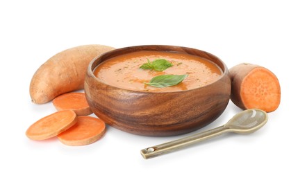 Photo of Delicious sweet potato soup with spices in bowl and fresh vegetables isolated on white