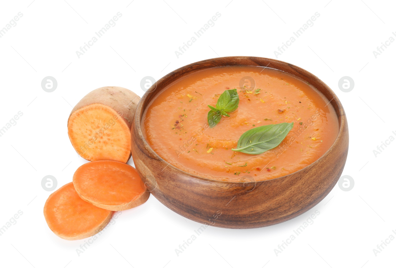 Photo of Delicious sweet potato soup with spices in bowl and cut vegetable isolated on white