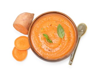 Photo of Delicious sweet potato soup with spices in bowl and cut vegetable isolated on white, top view