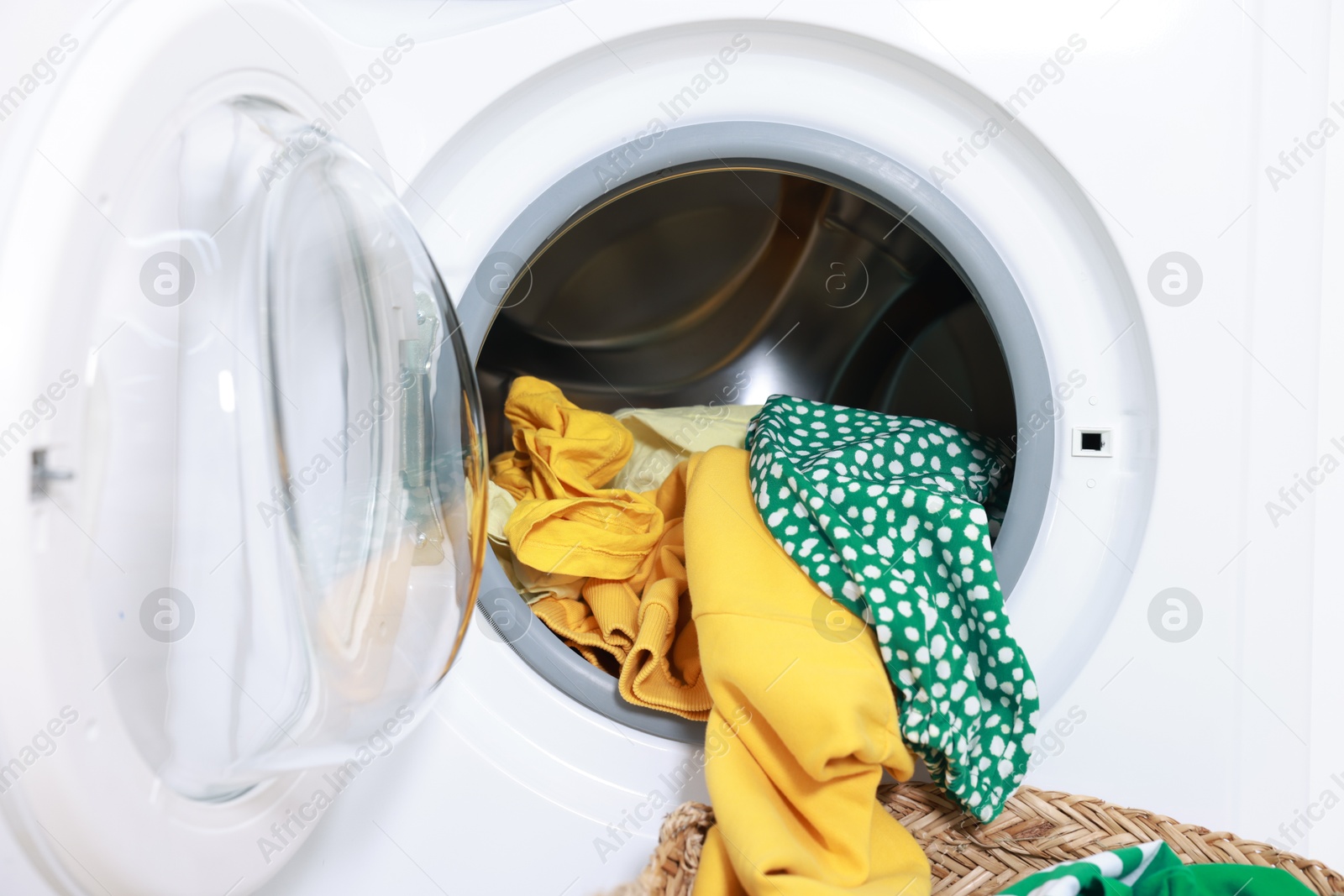 Photo of Modern washing machine with clothes in drum, closeup