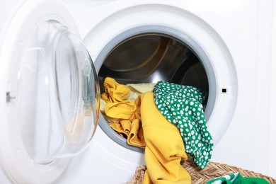 Photo of Modern washing machine with clothes in drum, closeup