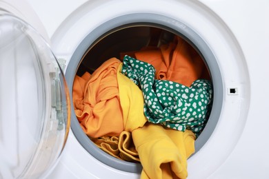 Photo of Modern washing machine with clothes in drum, closeup