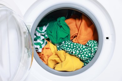 Photo of Modern washing machine with clothes in drum, closeup