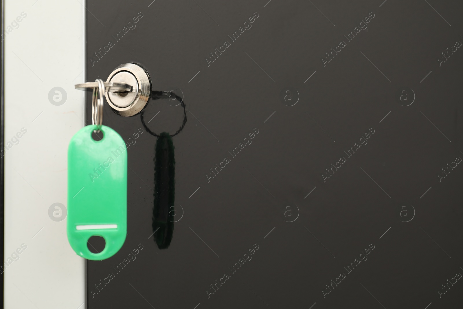 Photo of Modern locker with bright key, closeup view