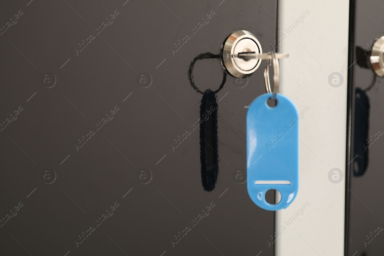 Photo of Modern locker with blue key, closeup view