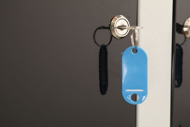 Photo of Modern locker with blue key, closeup view