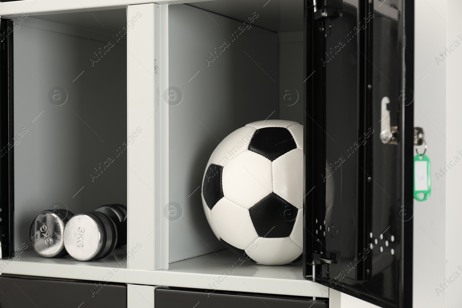 Photo of Open lockers with dumbbells and soccer ball, closeup