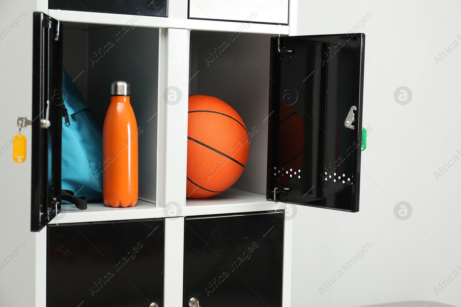 Photo of Lockers with personal belongings in changing room at gym, closeup