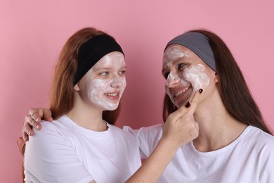 Photo of Teenage girls with masks on their faces and headbands against pink background