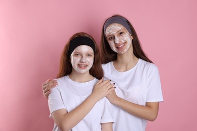 Photo of Teenage girls with masks on their faces and headbands against pink background