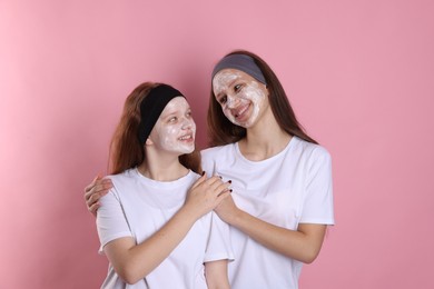 Photo of Teenage girls with masks on their faces and headbands against pink background