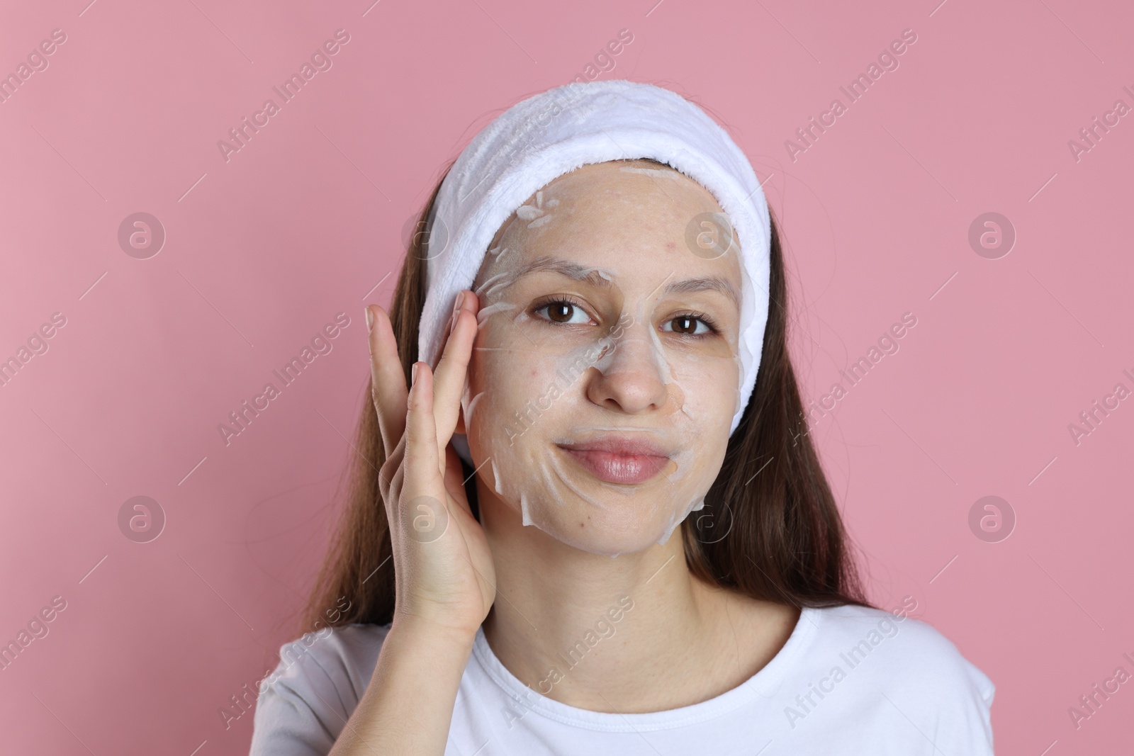 Photo of Teenage girl with sheet facial mask on pink background. Acne treatment