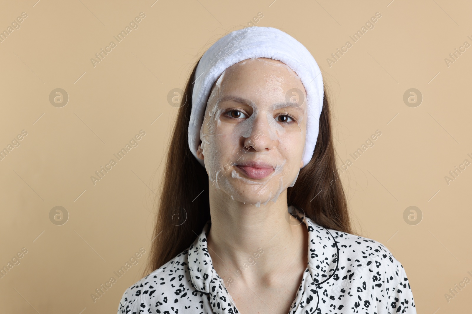 Photo of Teenage girl with sheet facial mask on beige background. Acne treatment